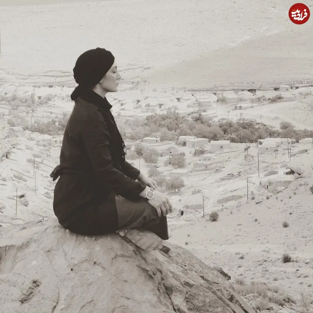 عکس سیاه سفید هدیه تهرانی نشسته بالای یک تپه درحال حس گرفتن با چشمان بسته