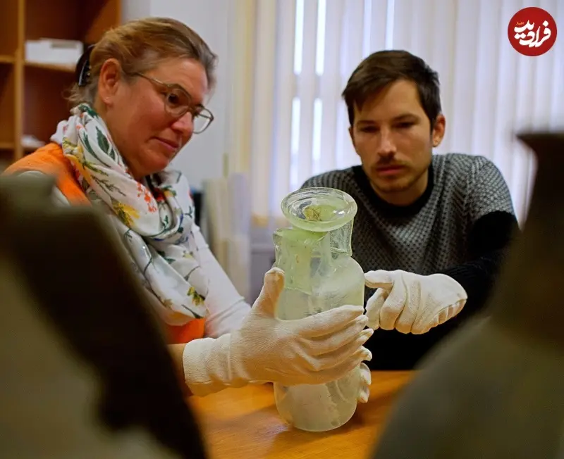Archaeologists-examine-intact-glass-vessel