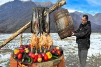 ببینید| غذای روستایی در آذربایجان؛ دودی کردن مرغ و ماهی در بشکه در هوای برفی روستا