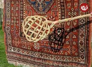 عکس| سفر به ایران قدیم؛ مرد اصفهانی در حال تکاندن قالی‌ها با چوب؛ سال 1340