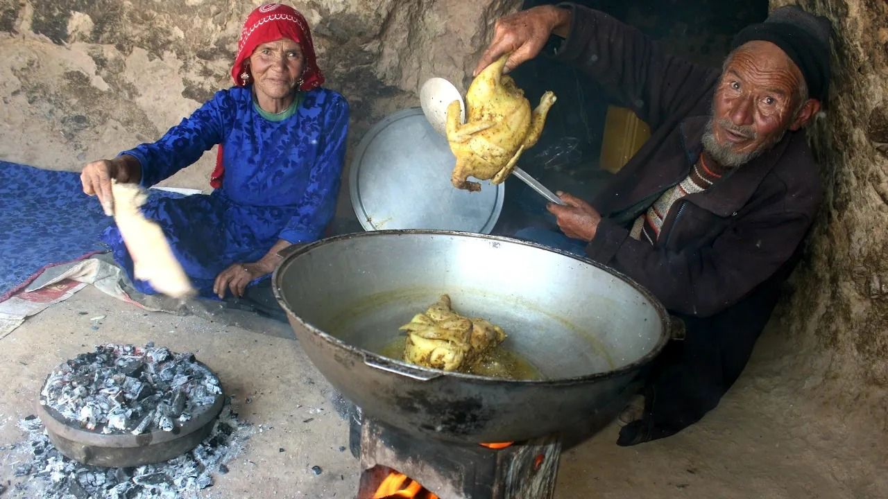 (ویدئو) زندگی زوج عاشق افغانستانی در غار باستانی؛ طبخ متفاوت مرغ کامل با نان سنتی