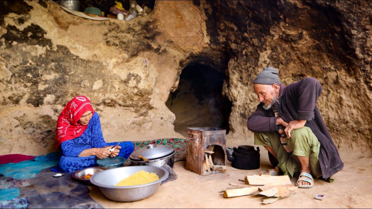 (ویدئو) زندگی عاشقانه زوج 80 ساله افغانستانی در غار؛ پخت متفاوت مرغ و سیب سرخ شده