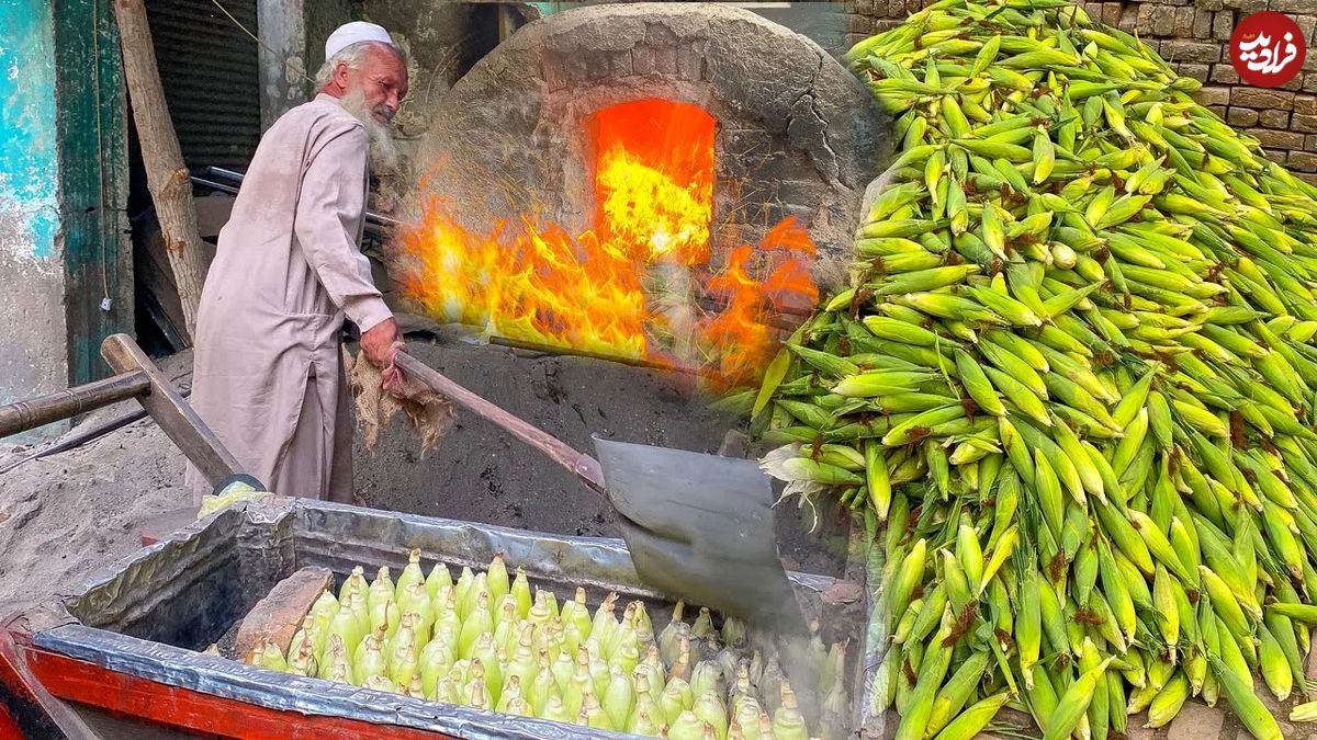 (ویدئو) ببینید این پیرمرد 70 ساله پاکستانی چگونه ذرت ها را برای فروش در شن داغ می پزد