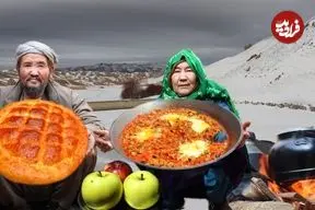ببینید| غذای روستایی در افغانستان؛ پخت کیک خانگی روی آتش توسط زوج مسن افغان