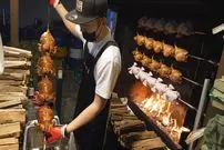 ببینید| غذای خیابانی در کره؛ کباب مرغ شکم پر روی هیزم بلوط در سئول