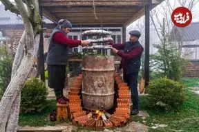 ببینید| غذای روستایی در آذربایجان؛ دودی کردن ماهی در بشکه