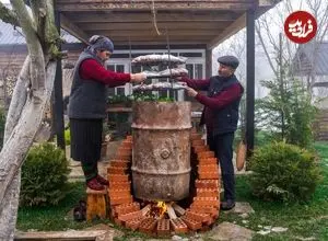 ببینید| غذای روستایی در آذربایجان؛ دودی کردن ماهی در بشکه