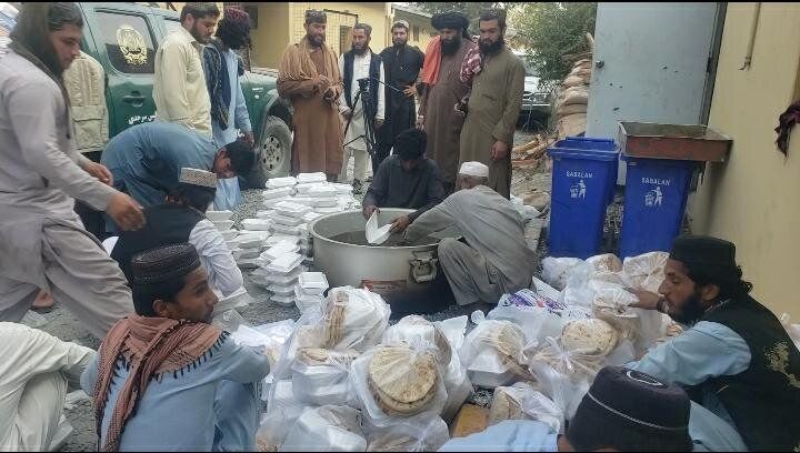 طالبان در حال پخش پول و غذا بین مهاجران افغان