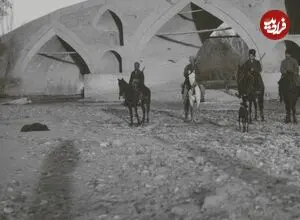 عکس| سفر زمان؛ سواران قاجاری در کنار یک پل و عبور کاروان شترها؛ 113 سال قبل