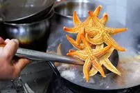 ببینید| غذای خیابانی در چین؛ ستاره دریایی سرخ شده با برنج در چینگ دائو