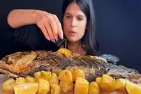 ببینید| غذا خوردن با صدا؛ خوردن ماهی بزرگ کبابی و سیب زمینی به روش دختر جوان یونانی