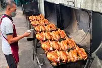 ببینید| غذای خیابانی در تایلند؛ کباب مرغ شکم پر روی زغال در خیابان های بانکوک