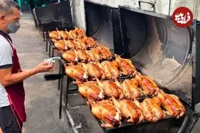 ببینید| غذای خیابانی در تایلند؛ کباب مرغ شکم پر روی زغال در خیابان های بانکوک