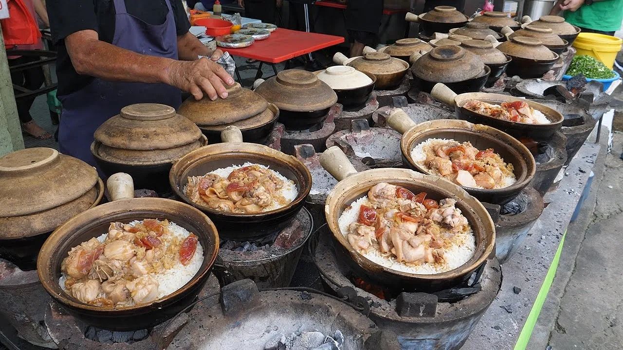 (ویدئو) ببینید این آشپز مشهور خیابانی در مالزی چگونه پلو مرغ گلدانی مشهورش را طبخ می کند