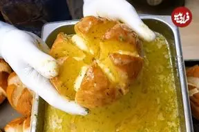 ببینید| غذای خیابانی در کره؛ پخت نان سیر و پنیر مجبوب در سئول