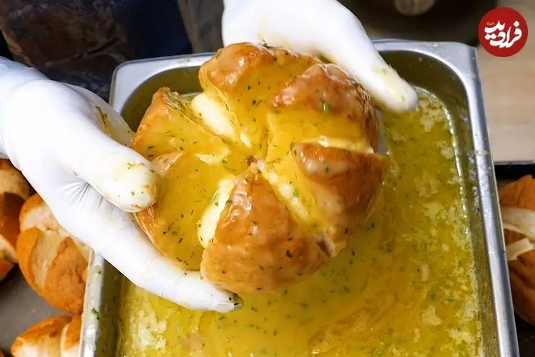 ببینید| غذای خیابانی در کره؛ پخت نان سیر و پنیر مجبوب در سئول