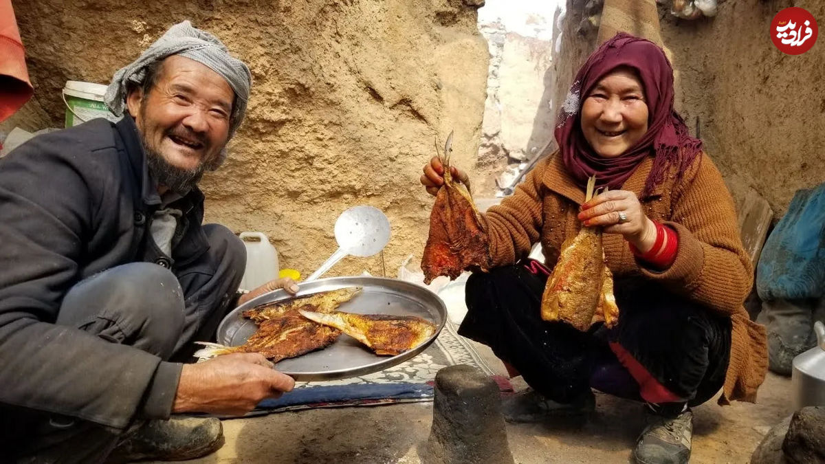 (ویدئو) پخت متفاوت ماهی توسط زوج غارنشین افغان در کوهستان های برفی 