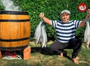 ببینید| غذای روستایی در آذربایجان؛ دودی کردن ماهی تازه در بشکه در روستا