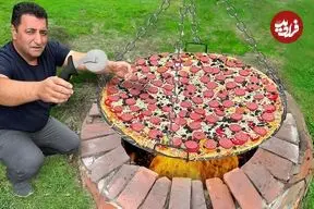 ببینید| غذای روستایی در آذربایجان؛ پخت پیتزای غول پیکر در تنور زیر زمینی