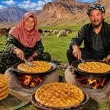 ببینید| غذای روستایی در افغانستان؛ پخت نان روغنی روی آتش توسط زوج مسن افغان