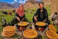 ببینید| غذای روستایی در افغانستان؛ پخت نان روغنی روی آتش توسط زوج مسن افغان