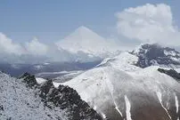عکس| سفر زمان؛ نمایی از کوه‌های شمال تهران در دوران قاجار؛ مردی نشسته بر فراز صخره‌ها