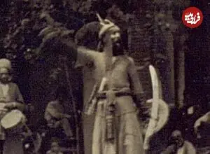 عکس| سفر زمان؛ یک تعزیه‌خوان در حال اجرای نمایش در یک خیابان خاکی در تهران؛ 140 سال قبل