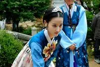 عکس| سفر زمان؛ «سوسانو» در حال گذاشتن پاکت پول در دهان خوک در پشت‌صحنه سریال «ججونگ‌وون»