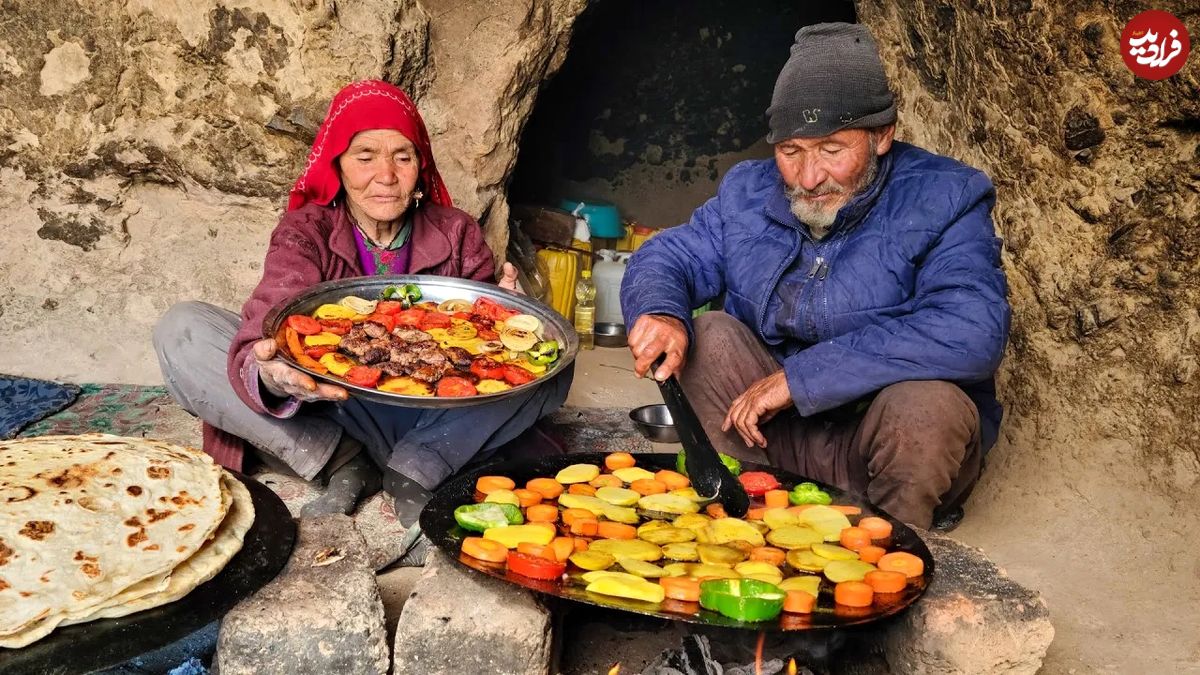 (ویدئو) نمایی دیدنی از پخت گوشت، سیب زمینی و گوجه روی ساج توسط زوج غارنشین افغان