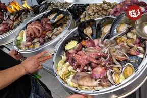 ببینید| غذای خیابانی در کره؛ پخت غذاهای محبوب با صدف و اختاپوس در سئول