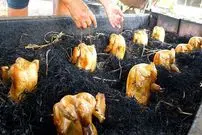 ببینید| غذای خیابانی در تایلند؛ کباب کردن مرغ کامل در زیر کاه در ناخن پاتوم