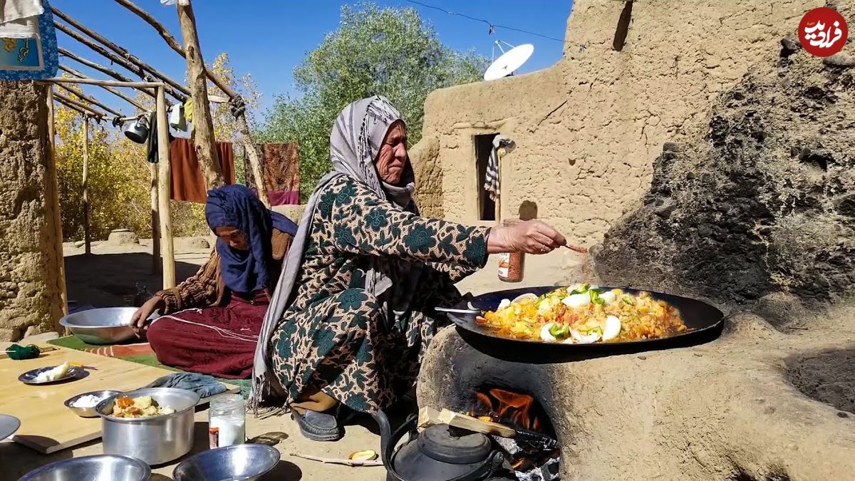 (ویدئو) پخت یک غذای محلی با کلم، گوجه و سیب زمینی روی ساج توسط دو زن روستایی افغانستانی