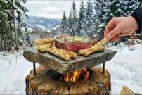 ببینید| غذای روستایی در لهستان؛ پخت استیک و تخم مرغ روی سنگ داغ در کوه های برفی