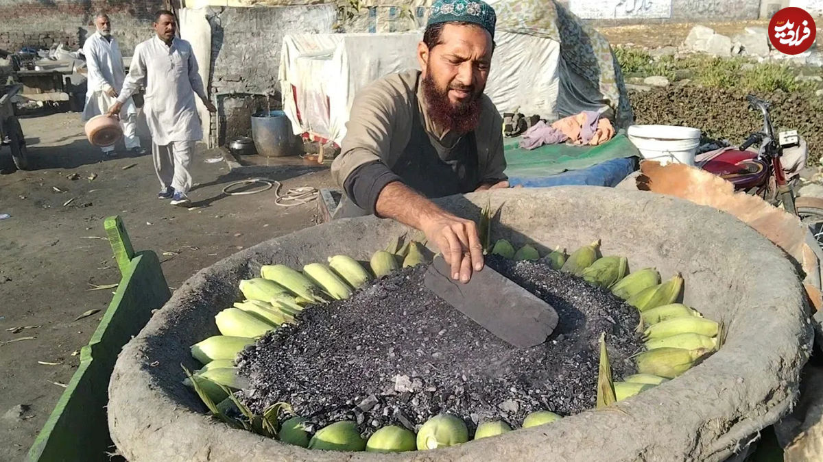 (ویدئو) غذای خیابانی در پاکستان؛ پخت بلال در ماسه داغ در پنجاب 