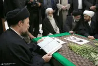 عکسی از قرآن خواندن سیدحسن خمینی بر مزار پدر همسرش