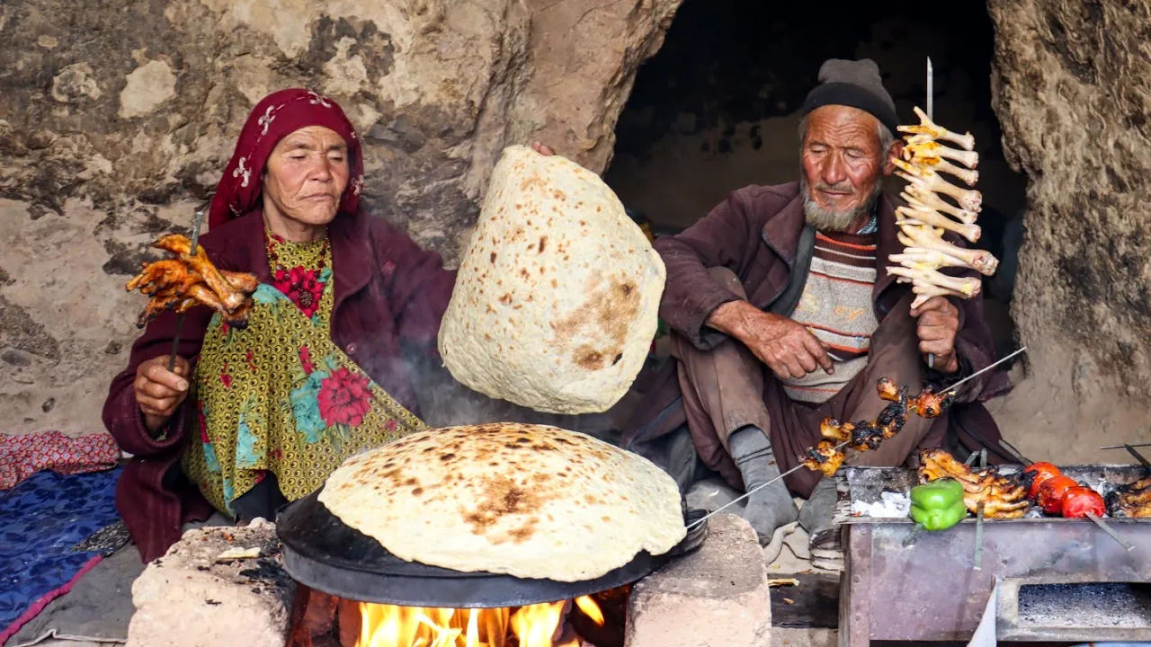 (ویدئو) پخت نان و کباب کردن پای مرغ در غار به روش یک زوج مسن افغان 