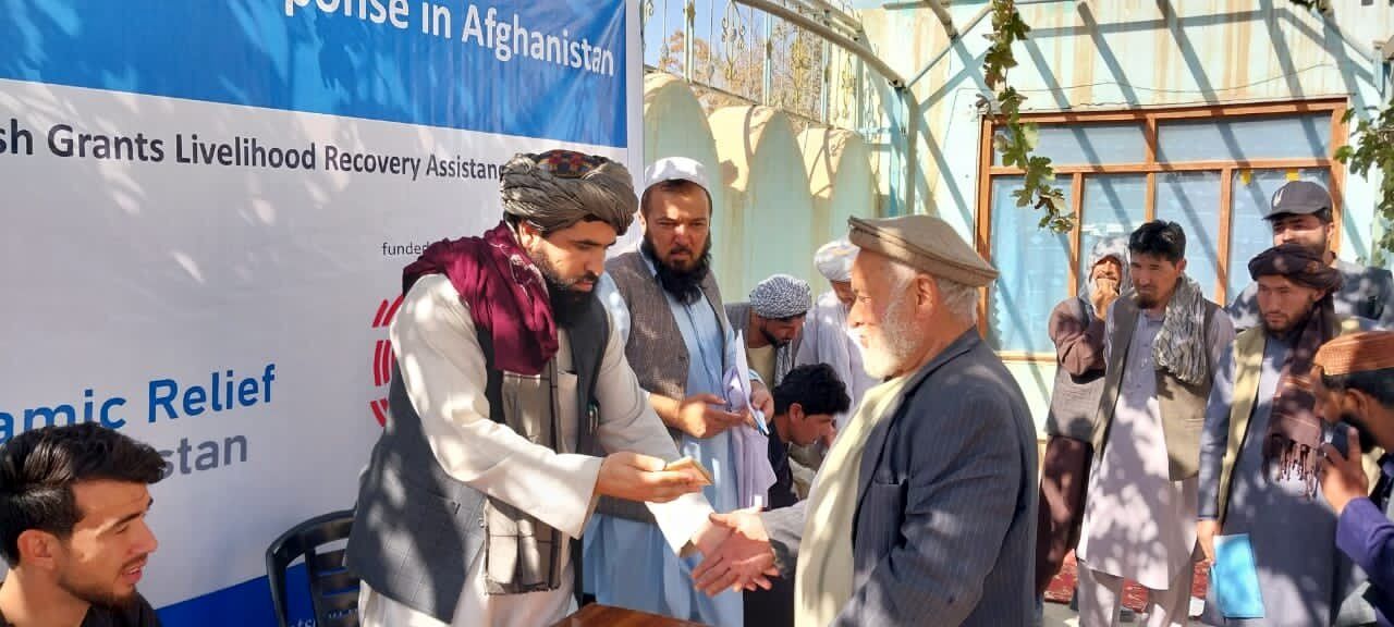 طالبان در حال پخش پول و غذا بین مهاجران افغان