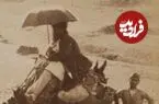عکس| سفر زمان؛ زن و مرد کجاوه‌سوار و مردی با چتر در حال سفر با کاروان؛ بیش از 100 سال قبل