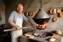 ببینید| غذای روستایی در چین؛ پخت نان باستانی شائوبینگ در تنور آویزان روی آتش در چین