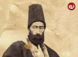 عکس| سفر زمان؛ تصویری از «خطاط مشهور دوران قاجار» در کنار یکی از نوشته‌هایش